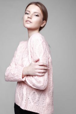 Aydınlık, geniş Studio'da şık rahat ve basit elbise gri bir arka plan ile poz bir kızın moda portre. temiz cilt ve mükemmel yüz genç kızla 