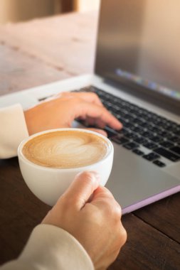 Laptop ve sıcak kahve ile çalışan kadın