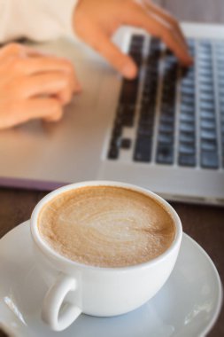 Laptop ve sıcak kahve ile çalışan kadın