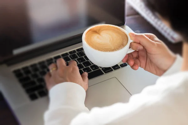 Main sur une tasse de café à la table de travail — Photo