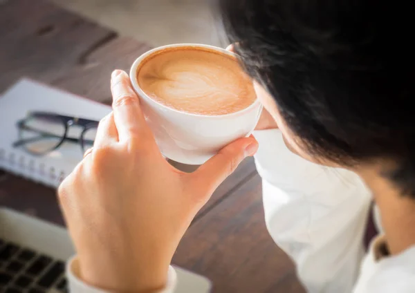 Handen på kopp kaffe på tabellen arbete — Stockfoto
