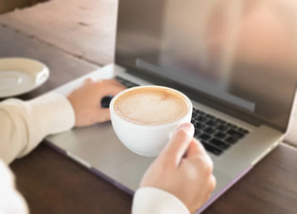 Mujer trabajando con portátil y café caliente — Foto de Stock