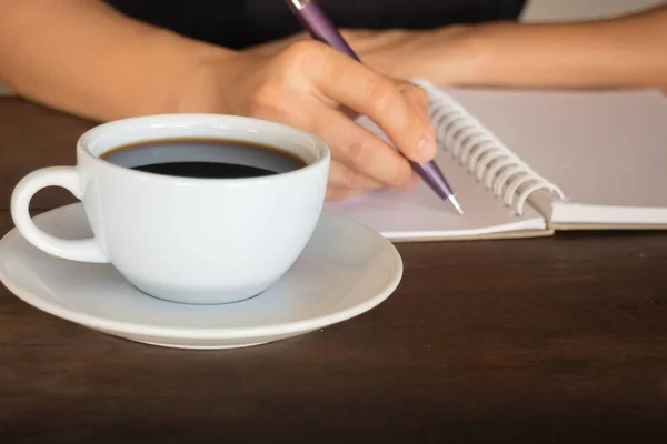 Hot cup of coffee on working table — Stock Photo, Image