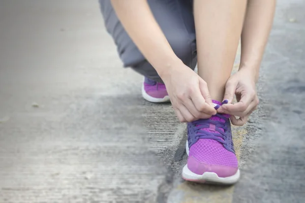 Woman tying her shoes preparing for a jog