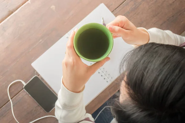 Lavoro tavolo creativo e tè verde caldo bere — Foto Stock