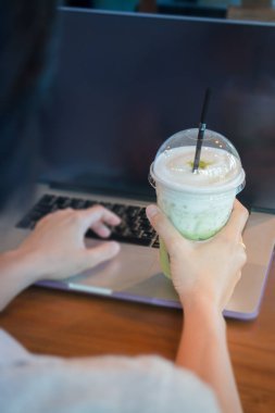 Kadın el yazma sırasında buzlu süt yeşil çayı