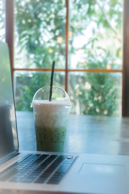 Kahve dükkanında ahşap masa üstünde laptop