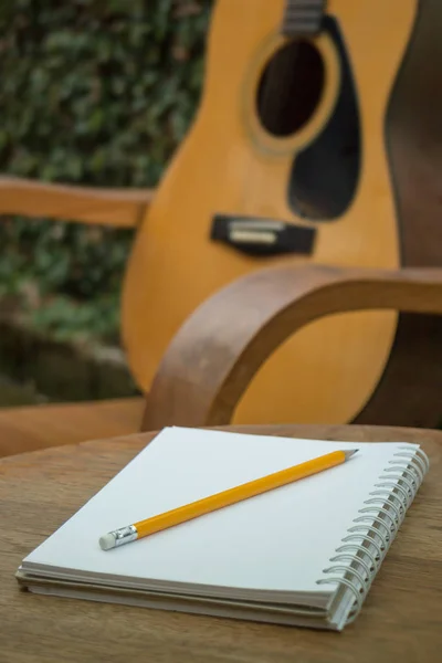 木制的桌子上的黄色木吉他 — 图库照片