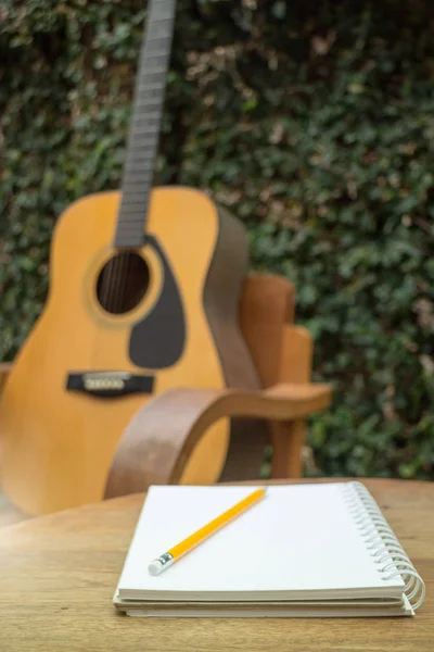 Guitarra acústica amarilla en mesa de madera —  Fotos de Stock