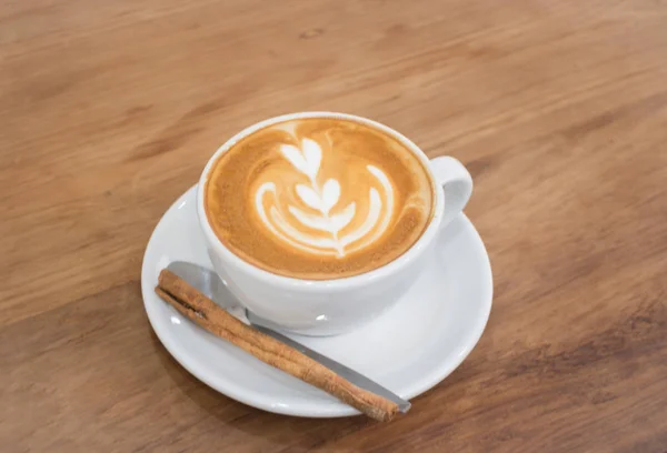 Кофе с искусством латте на деревянном столе — стоковое фото