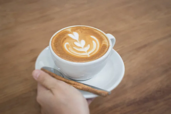 熱い一杯のコーヒーのカフェラテに手します。 — ストック写真