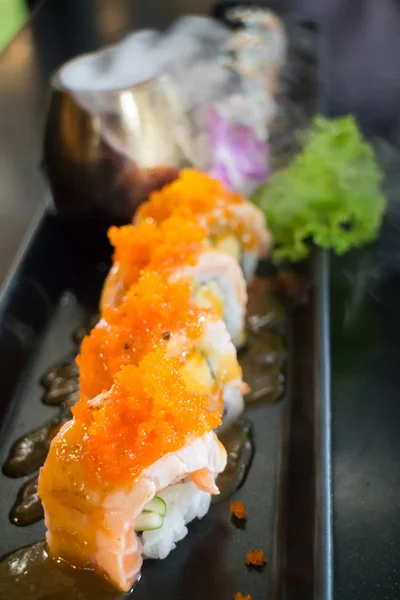 Sushi de salmão servido na placa preta — Fotografia de Stock