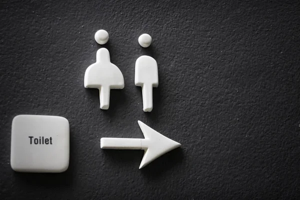 Men and ladies signs on black concrete wall — Stock Photo, Image