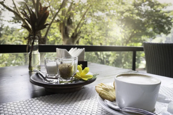 Gorąca kawa latte na balkon drewniany stół — Zdjęcie stockowe