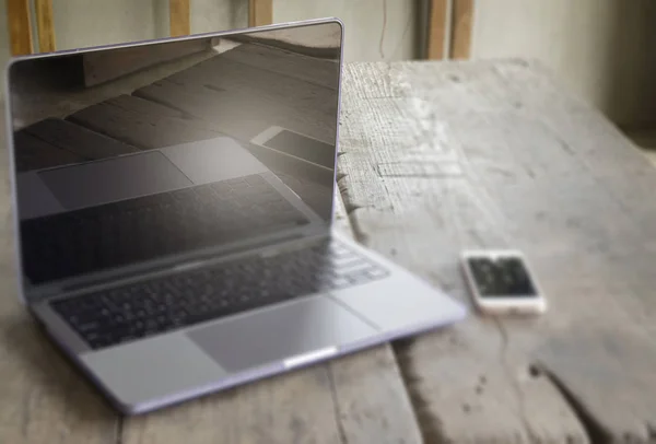 Laptop metal cinza moderno e telefone inteligente na mesa de madeira — Fotografia de Stock