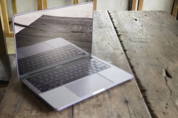 Современный серый металлический ноутбук на деревянном столе — стоковое фото