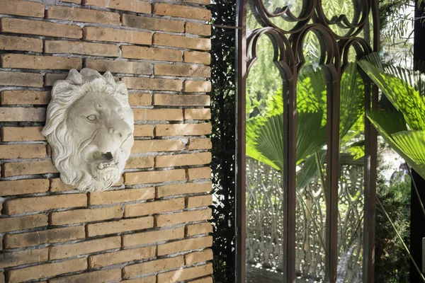 Statue of lion head on brick wall — Stock Photo, Image