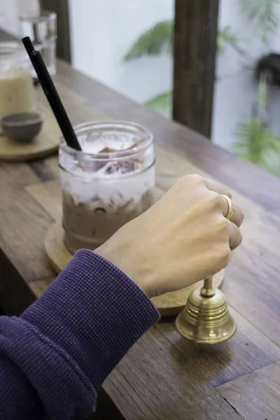 Hand op brass bell in de coffeeshop — Stockfoto