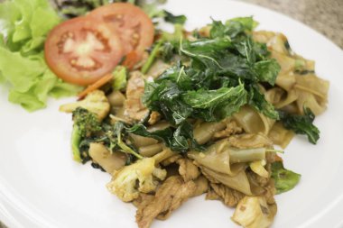 Baharatlı karıştırın kızarmış düz şehriye kutsal fesleğen yaprakları ile