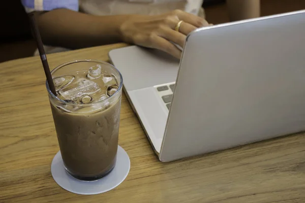 Стакан молочного кофе на деревянном столе — стоковое фото