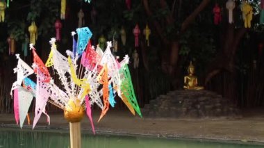 Buddha statue and cutting craft flags in Thai public temple, stock footage