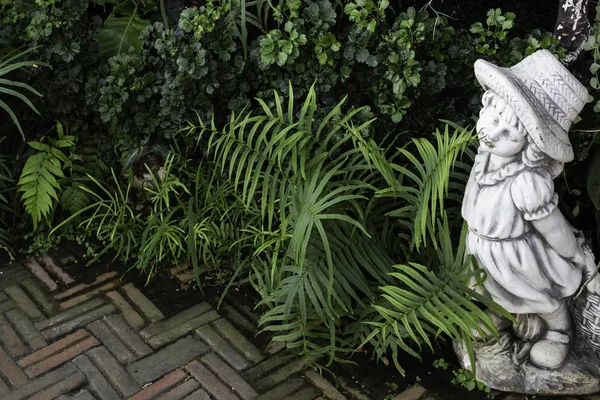 Green garden decorated with little girl doll — 스톡 사진