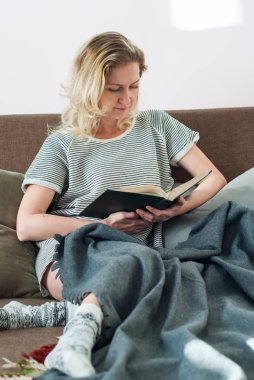 Güzel kız okuma kitabı yumuşak yatakta yatan