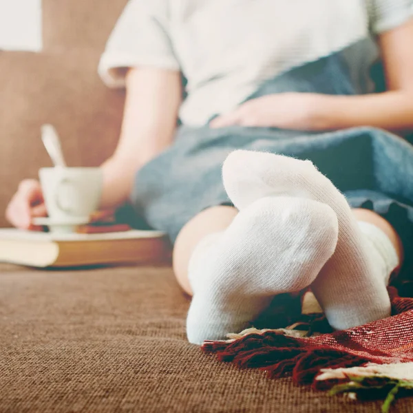 Sofá de mujer de calcetines blancos con reposo de leche de copa — Foto de Stock