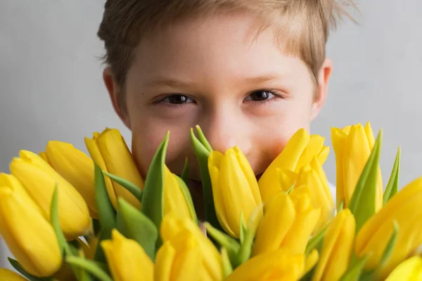 Garoto sorridente com tulipas de buquê amarelo para mulher — Fotografia de Stock