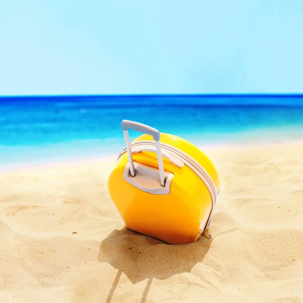 Vakantie accessoire geel koffer tropisch strand — Stockfoto