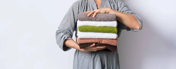 Женская рука взять стек полотенца для ванны красочный хлопок — стоковое фото