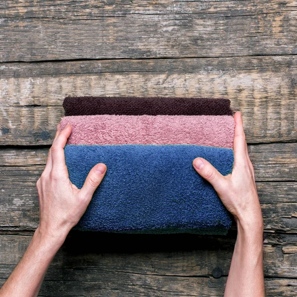 Γυναικεία χέρια κρατά στοίβα λουτρό πετσέτες βαμβακιού — Φωτογραφία Αρχείου
