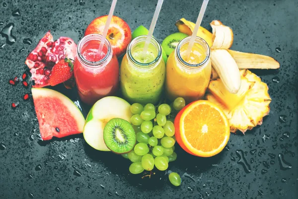 Friss gyümölcslevek présel palackok piros zöld narancs — Stock Fotó