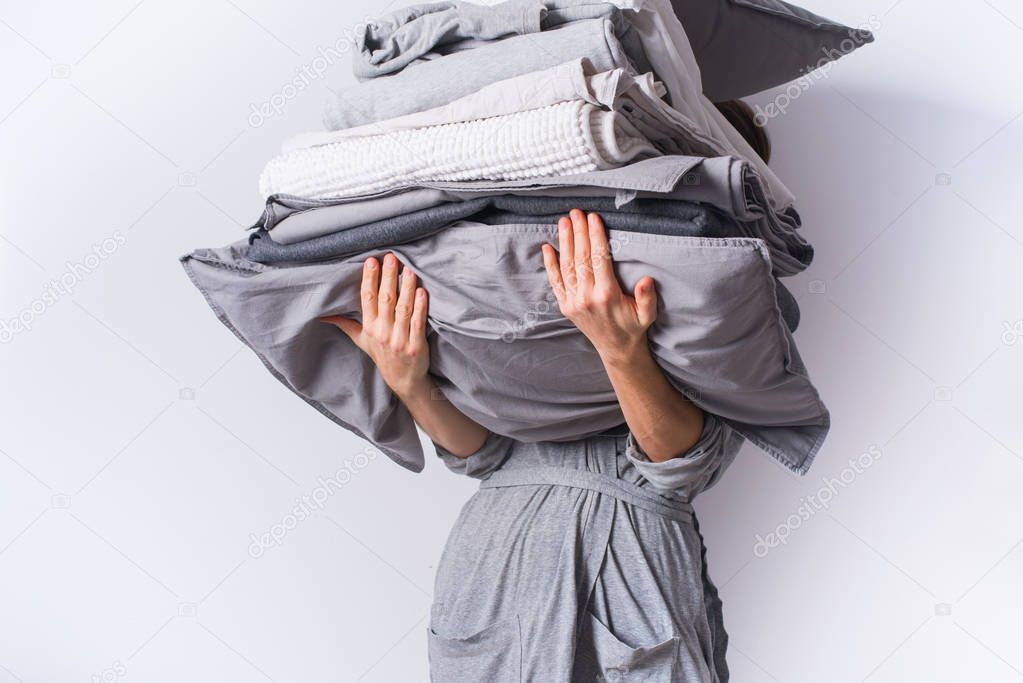female hands holding stack bed linen textiles