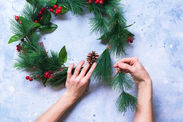 Vrouw maakt groene kerst decoratieve krans — Stockfoto