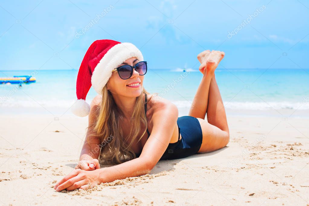 suntan woman relaxing beach christmas santa hat