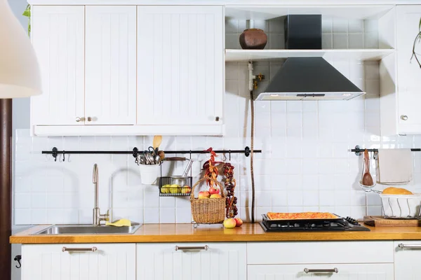 Λευκή εσωτερική πρόσοψη κουζίνας και ξύλινη επιφάνεια τραπεζιού — Φωτογραφία Αρχείου