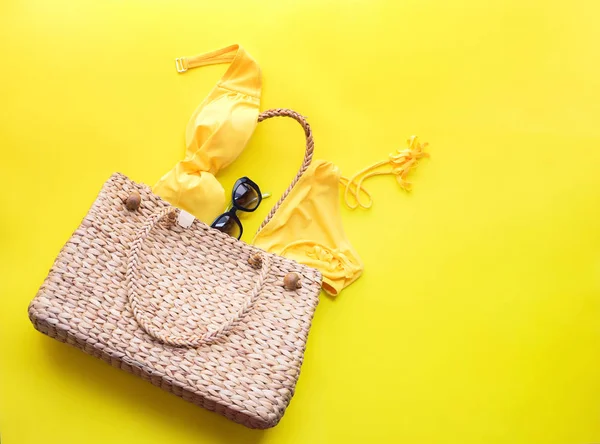 Wattled bag and women 's bathing suit on yellow — стоковое фото
