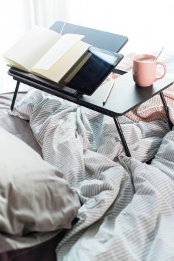 Kahve, günlük, masadaki kalem rahat gri yatakta.