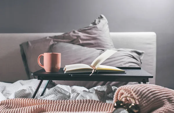 Coffee, daily, pencil on table on cosy grey bed — Stock Photo, Image
