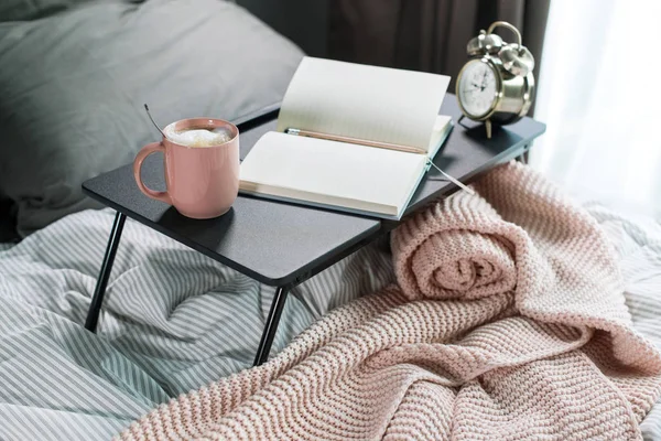 Coffee, daily, pencil on table on cosy grey bed