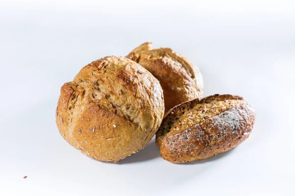 Gruppo di pane di grano integrale con semi su luce — Foto Stock
