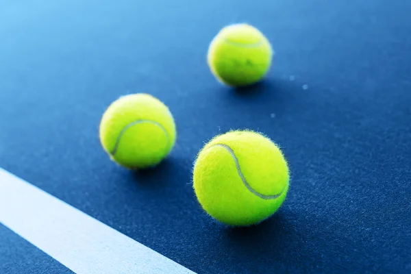 Tennisballen op een tennisbaan naast de witte lijn — Stockfoto