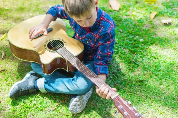 Счастливчик Клетчатой Рубашке Играет Гитаре Парке Зеленой Траве Урок Музыки — стоковое фото