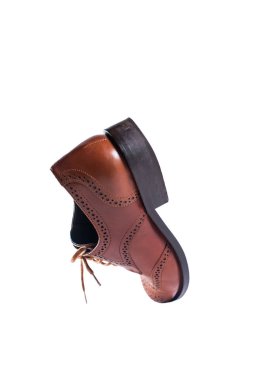 Klasik kahverengi deri ayakkabılar perspektifte ve beyaz arka planda izole. Nesnelerin uçuşu. Havada yükselme kavramı.