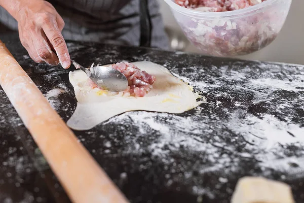 女性の手詰めは 自宅でテーブルの上にミンチ肉でパイ生地を転がしました 自家製のウズベクパイ サムサ料理のためのミンチビーフ アジア料理 — ストック写真