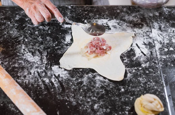 女性の手詰めは 自宅でテーブルの上にミンチ肉でパイ生地を転がしました 自家製のウズベクパイ サムサ料理のためのミンチビーフ アジア料理 — ストック写真
