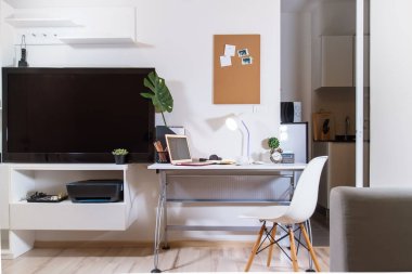 Bilgisayar dizüstü bilgisayarı ve sandalyesi olan beyaz bir iş yeri. Uzaktan kumandalı ev. Karantina süresince evde kalıp çevrimiçi çalışacaksın. Online eğitim. Kriz. Boşalt