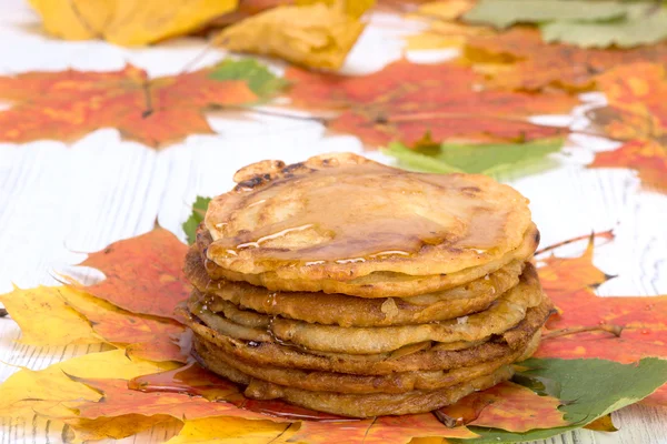 Frittelle con sciroppo d'acero su foglie multicolori autunnali — Foto Stock