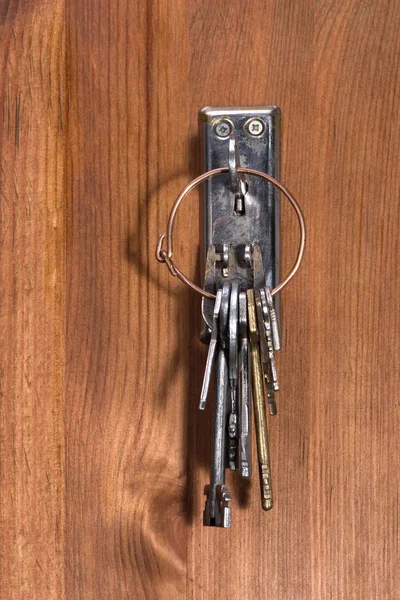 Retro key on the bunch is inserted into the keyhole — Stock Photo, Image
